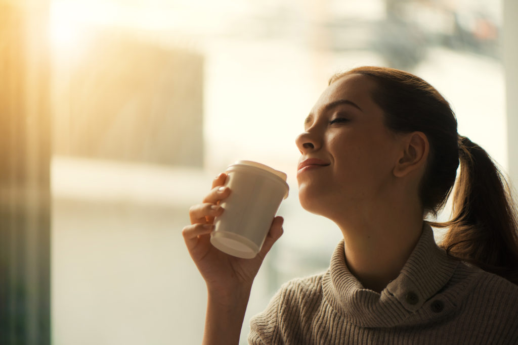 Woman drinking coffee at home with sunrise streaming in through Love is about second chances. We need to offer those chances to others just as God offers them to us.